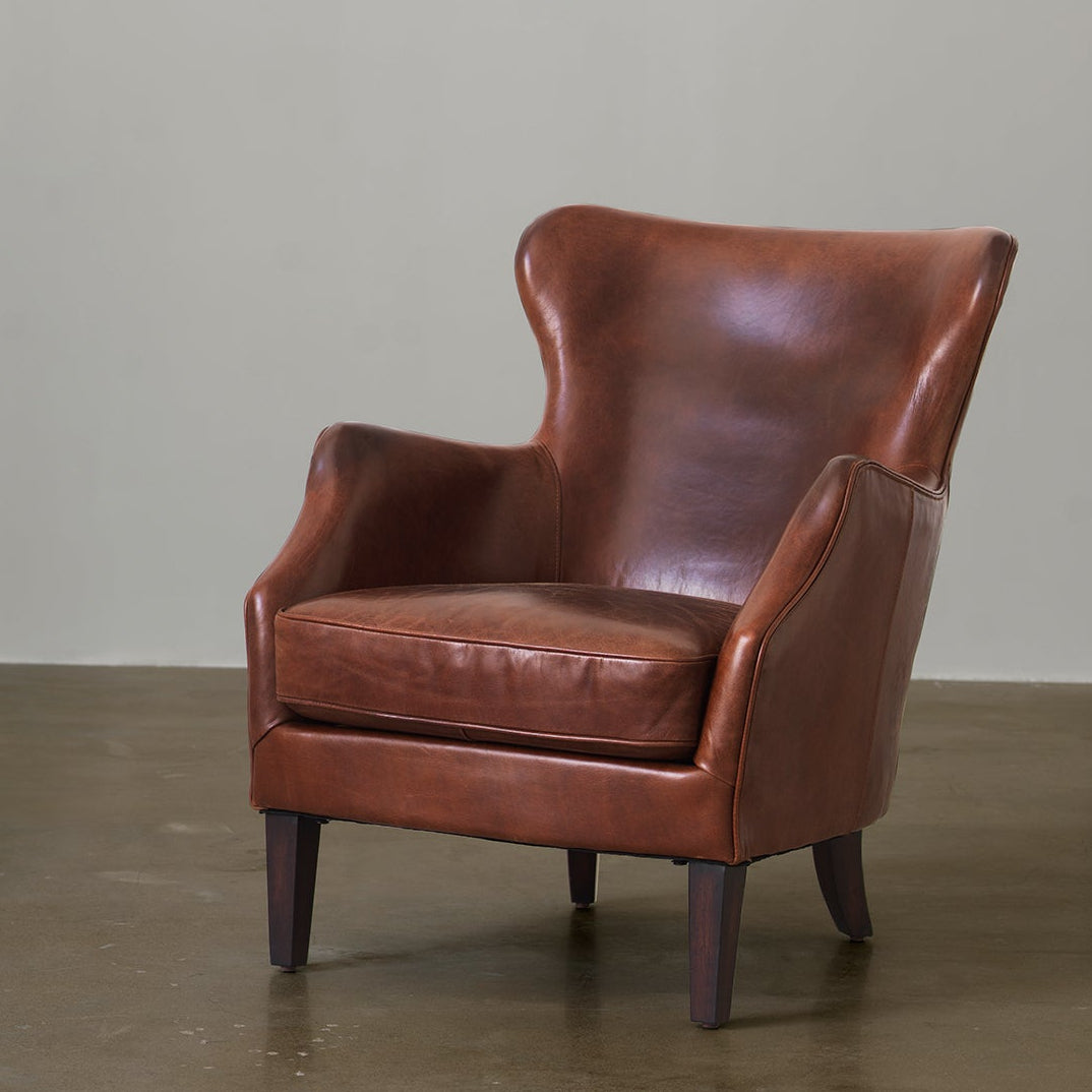 Vintage cowhide leather wingback chair front three-quarter view