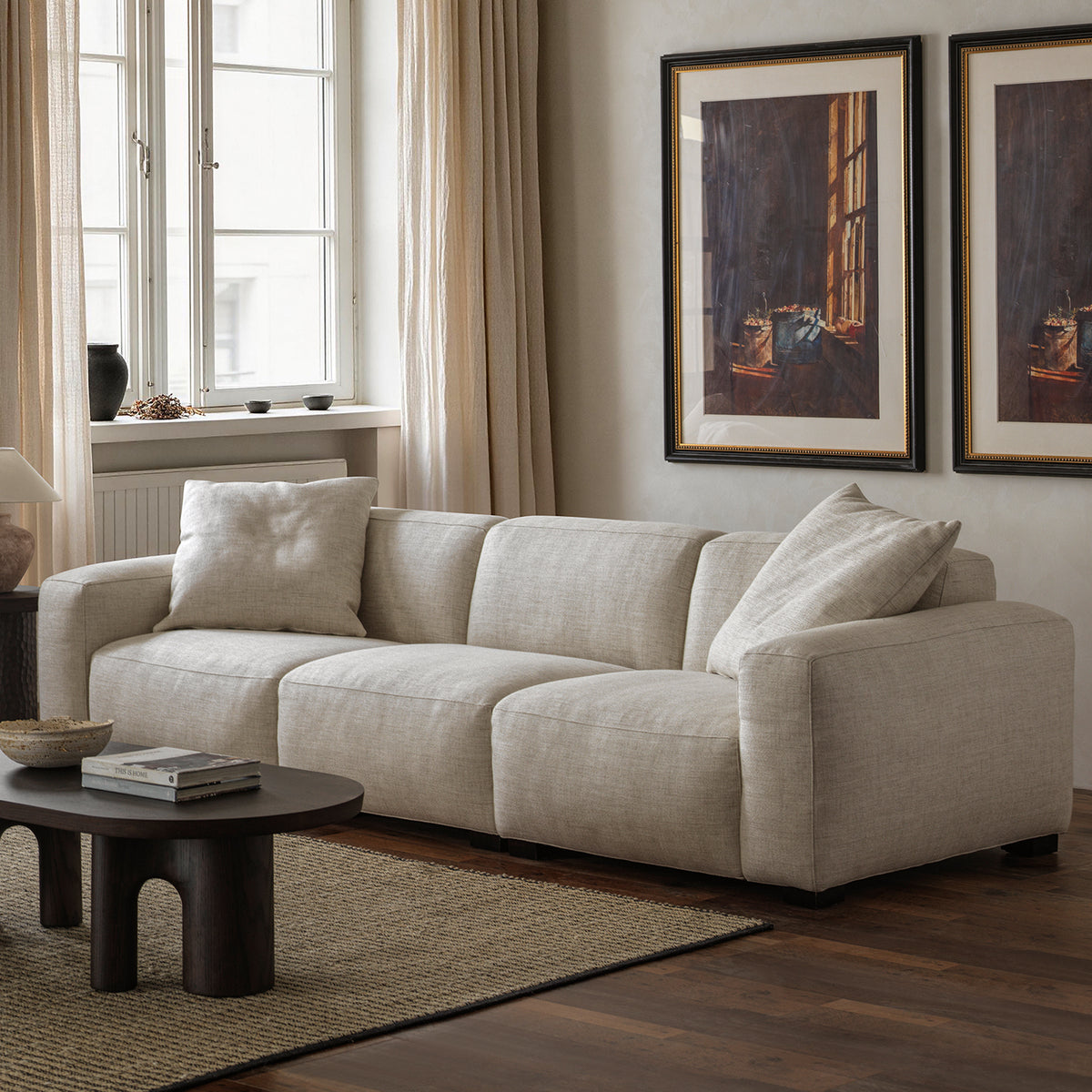 Cream upholstered sofa with broad arms in modern interior