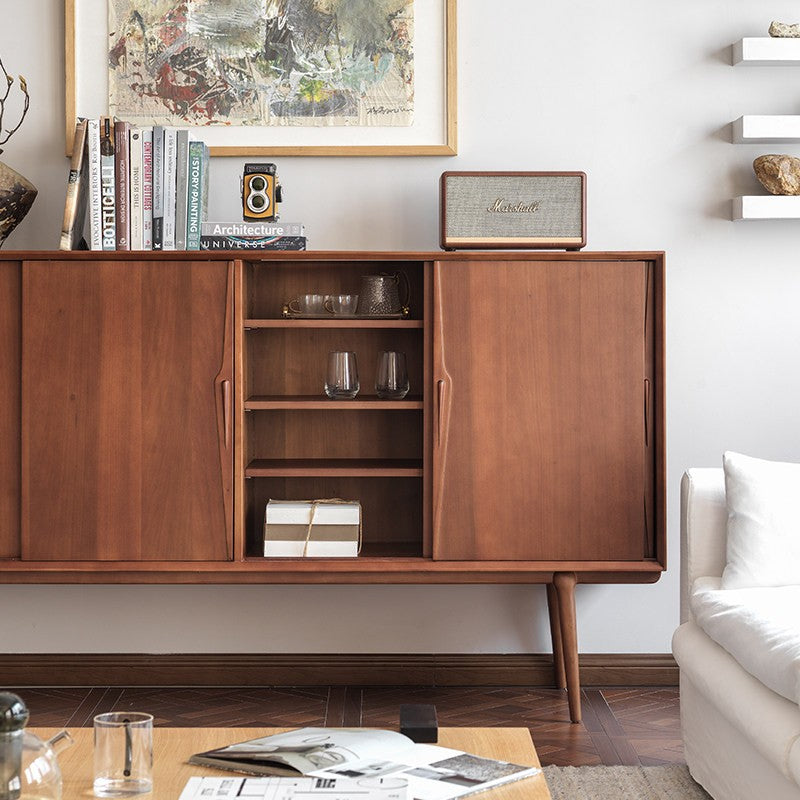 Sliding door of a boxwood sideboard opened to reveal interior shelves with glassware