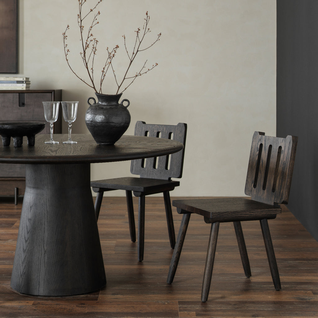 Close-up three-quarter view showing distressed solid wood conical pedestal base and matching chairs