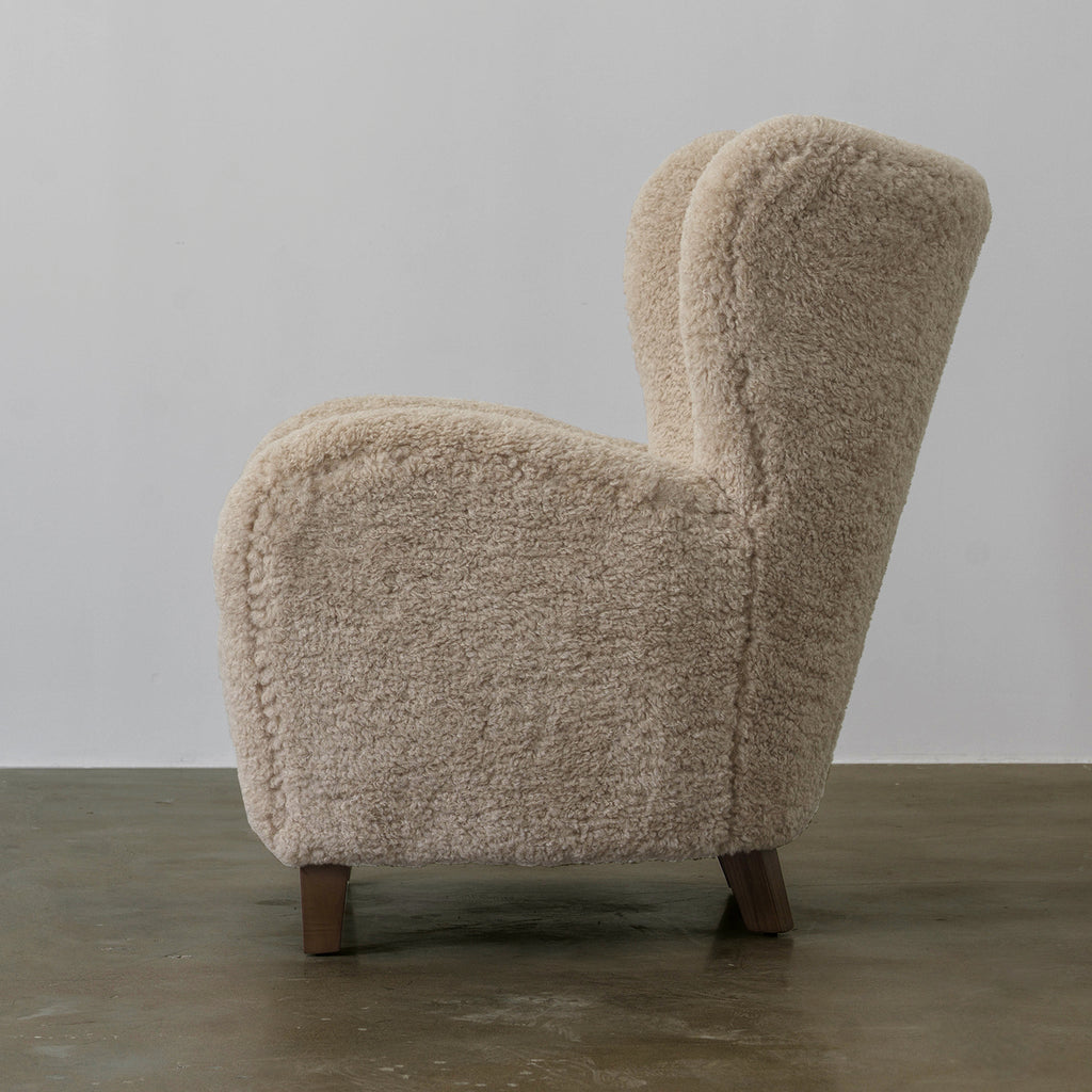 Side profile of Youran high-back fabric lounge chair showing its curved arm and short legs