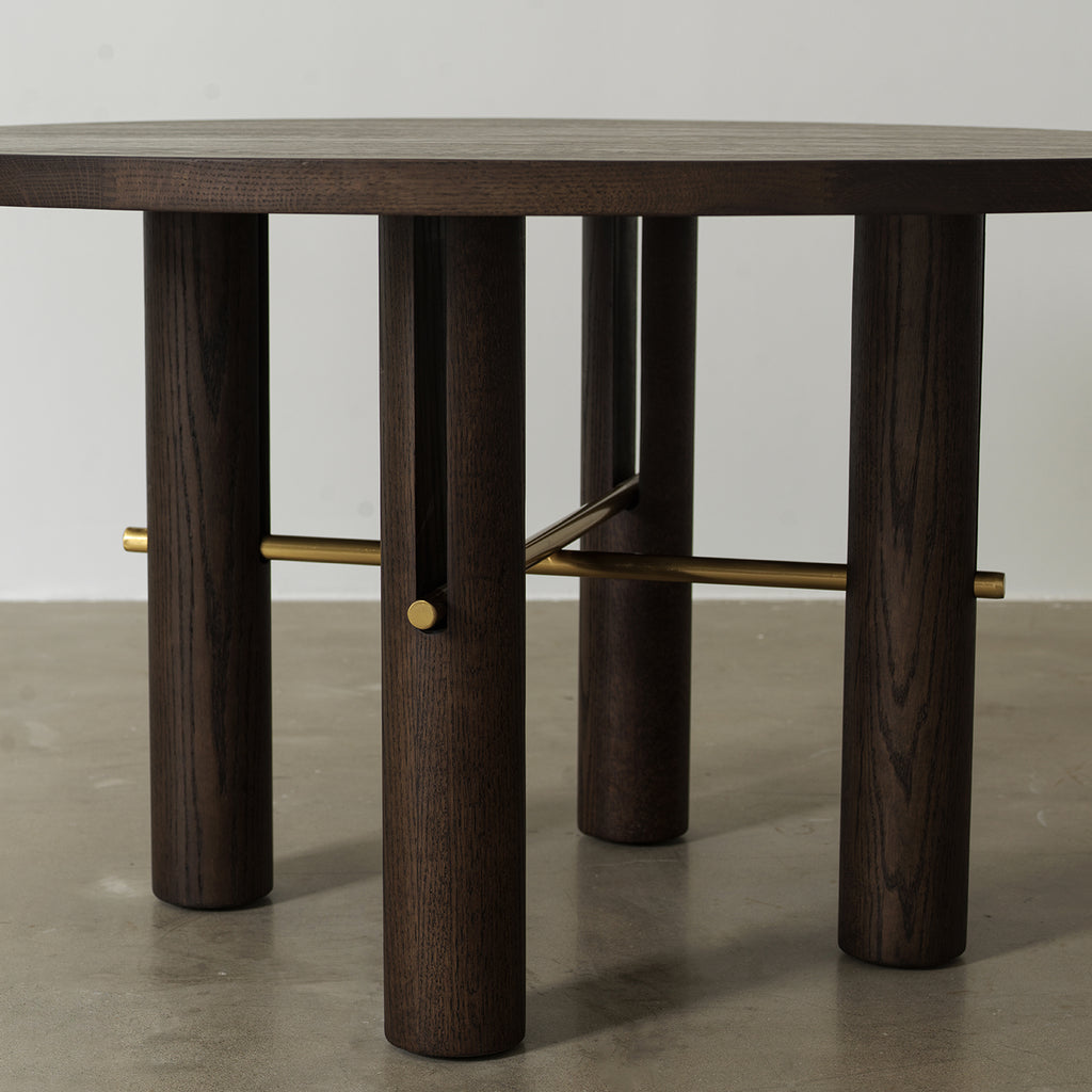 Four cylindrical pillar legs connected by antique brass metal cross stretcher rods, base structure detail