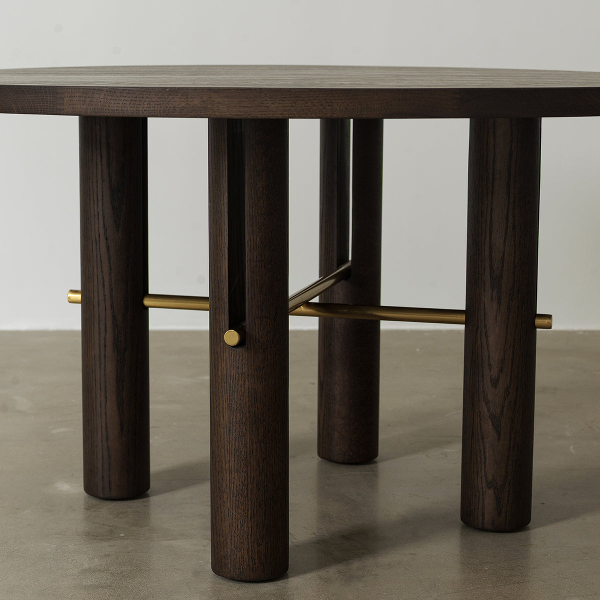 Four cylindrical pillar legs connected by antique brass metal cross stretcher rods, base structure detail