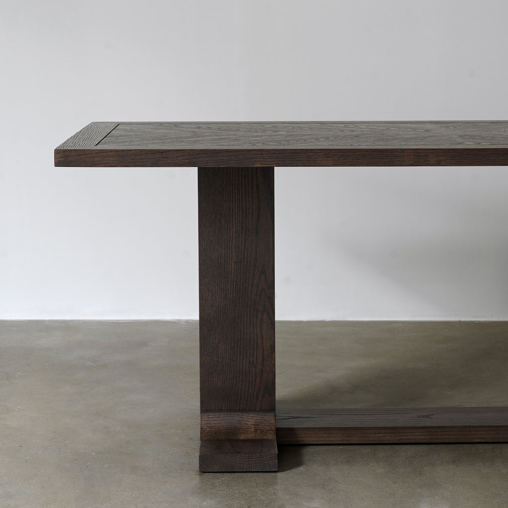 Side view of distressed wood dining table highlighting rectangular tabletop profile and trestle support structure