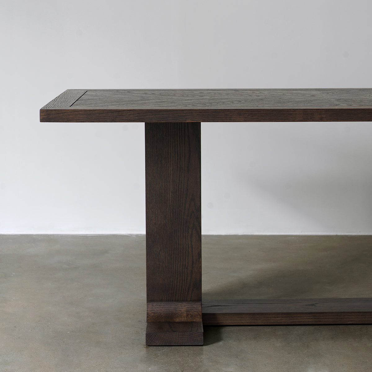 Side view of distressed wood dining table highlighting rectangular tabletop profile and trestle support structure