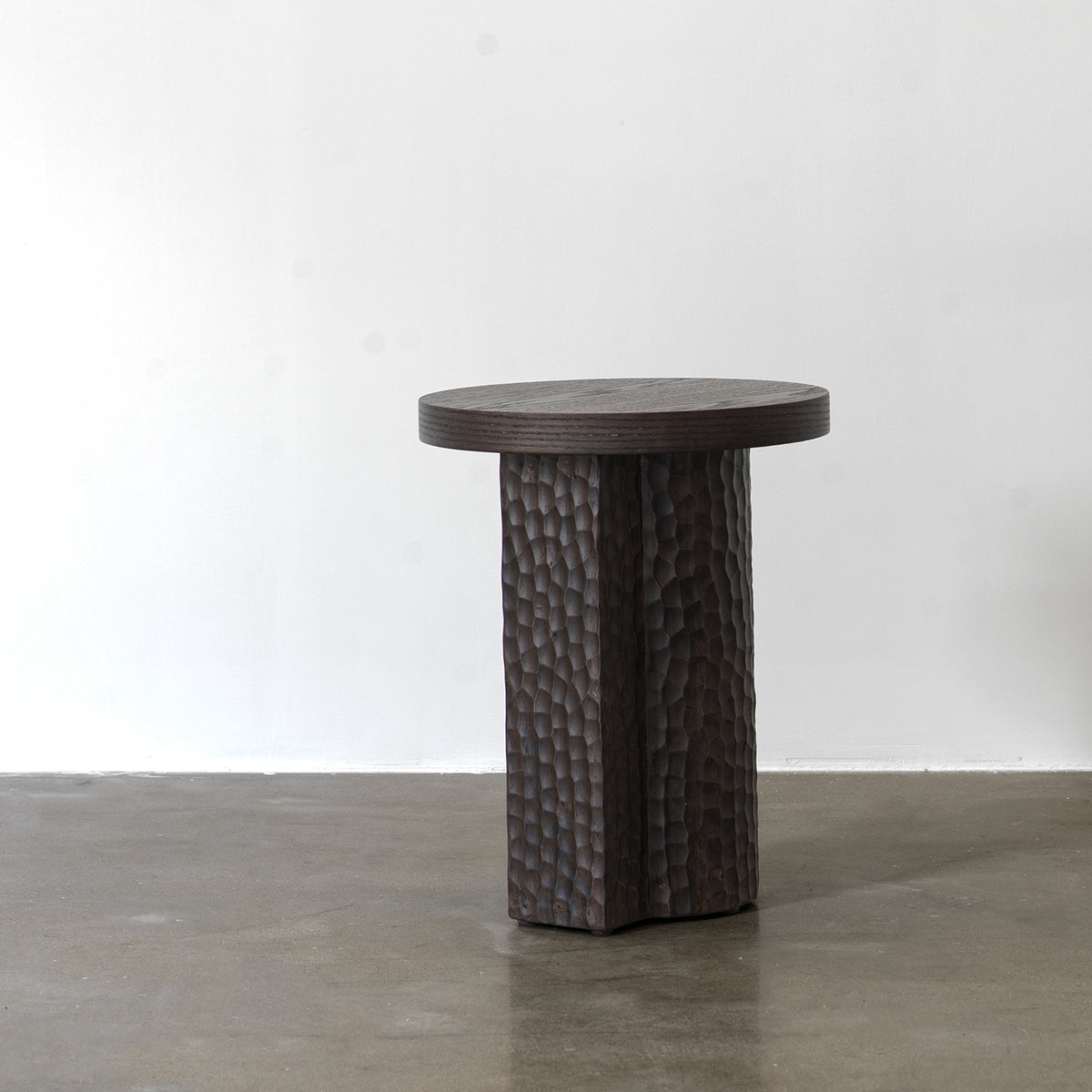 Full side view of distressed red oak accent table highlighting sculptural column pedestal