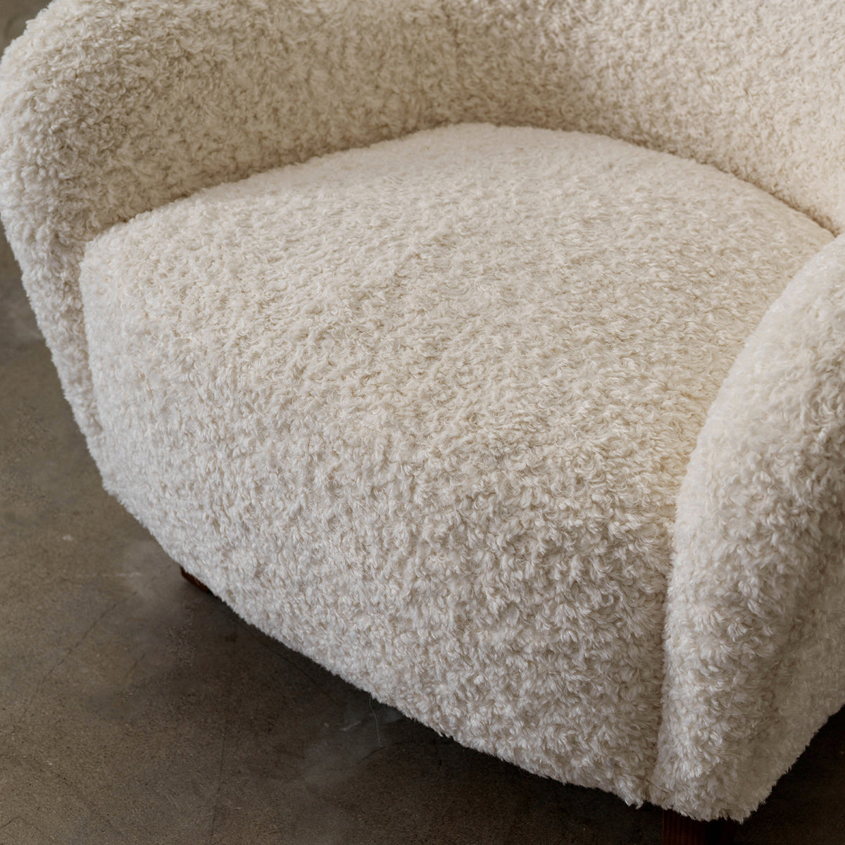 Detail of Nuantuo accent chair seat and nubby cream fabric upholstery