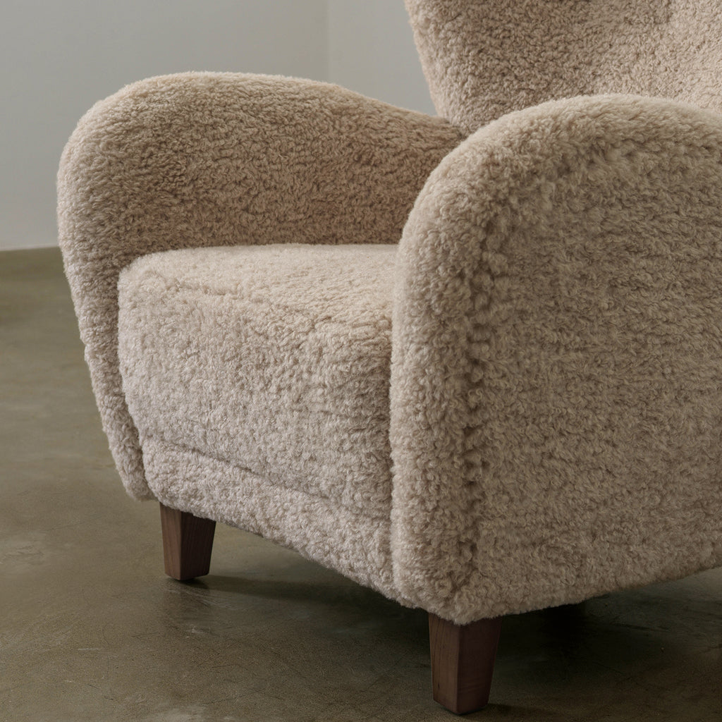 Youran lounge chair seat cushion and curved arm detail in beige textured upholstery