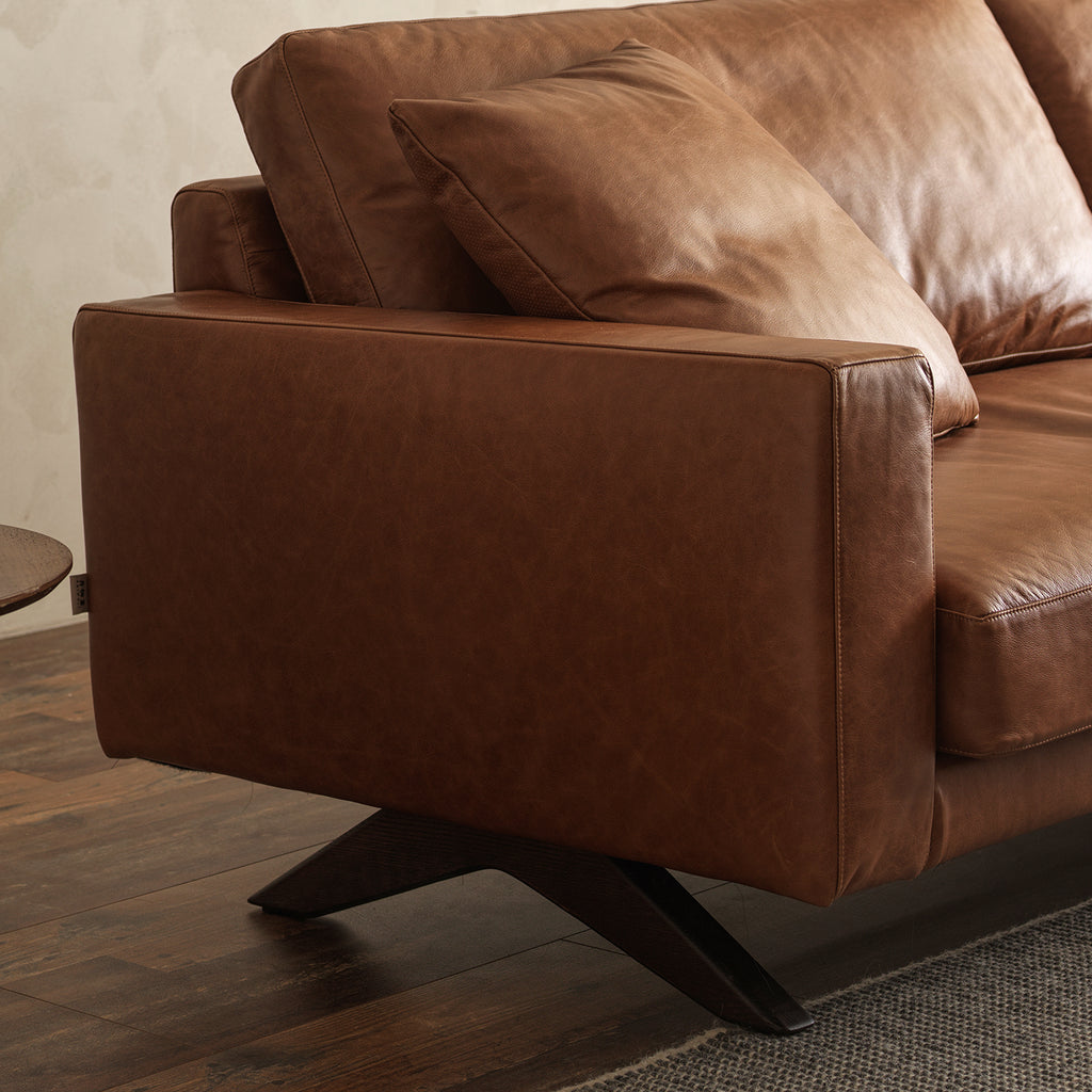 Side profile detail of low track armrest and dark stained angled wooden leg base