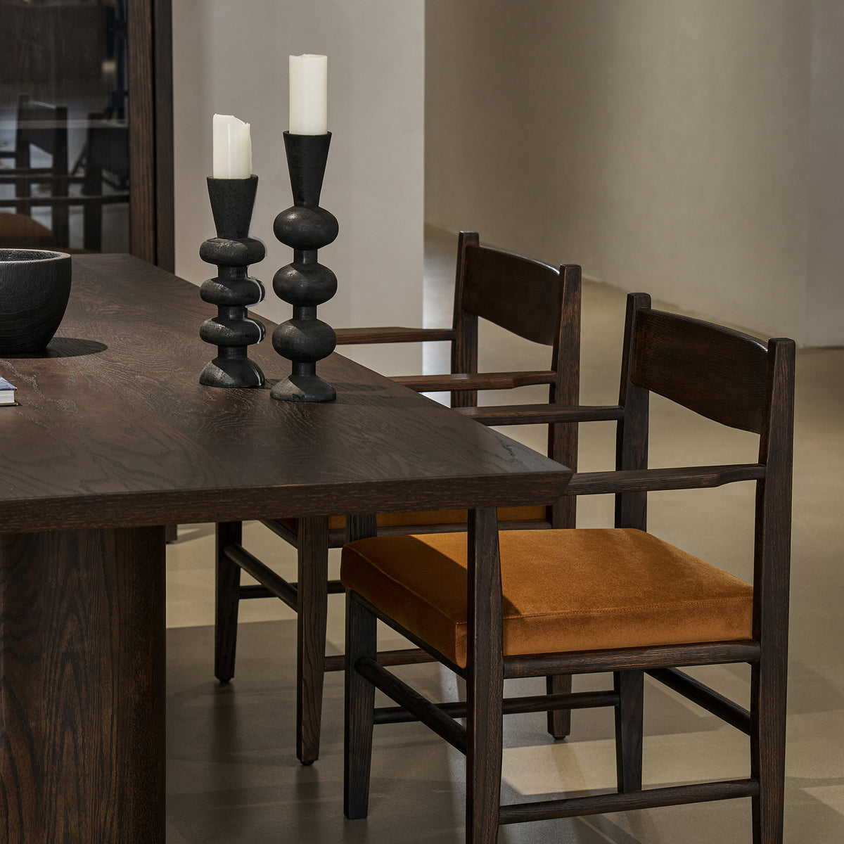 Angled side view showing tabletop thickness, chamfered edge, and chair placement along the dining table