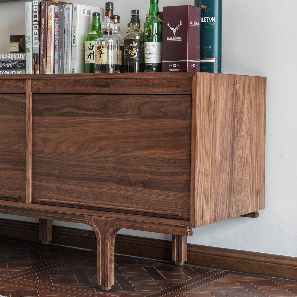  Side view of a black walnut sideboard showing the wood side panel and sculpted leg detail