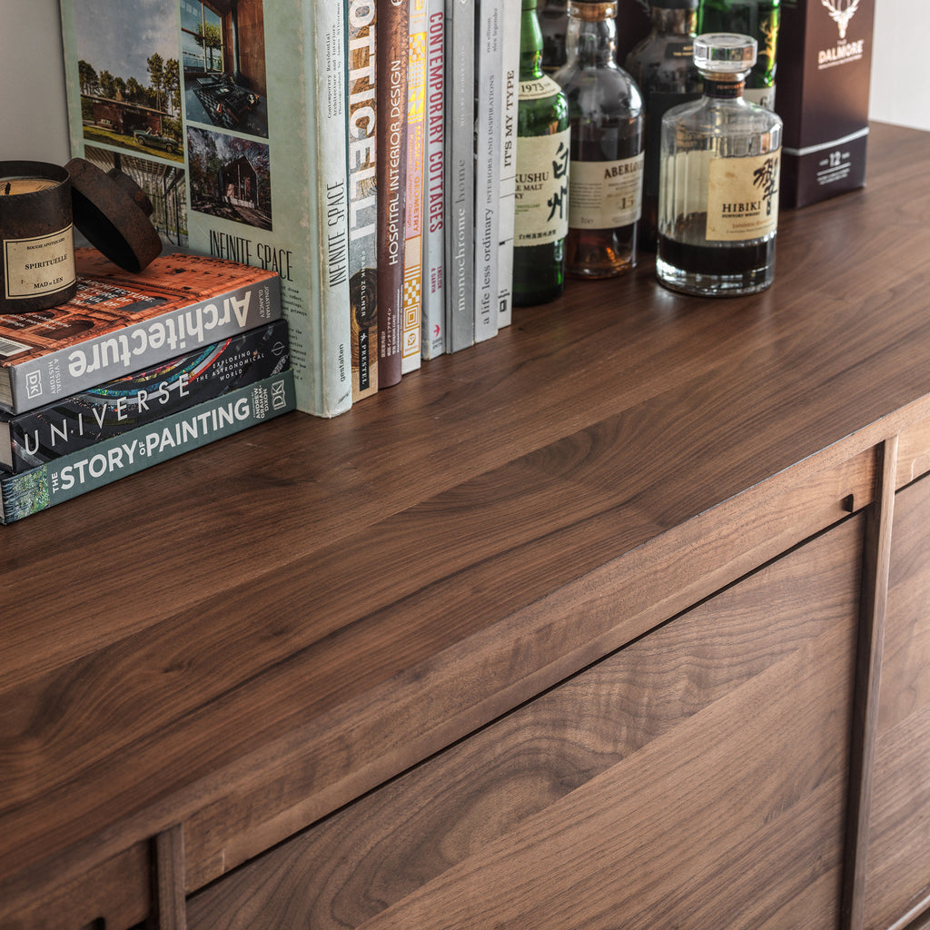 Black walnut wood grain detail on the sideboard top surface and door edge