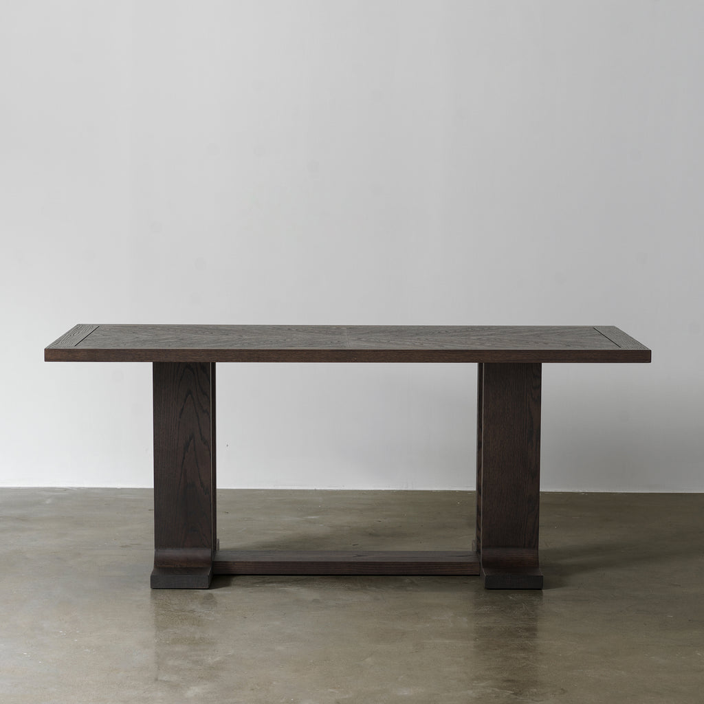 Front view of vintage distressed wood dining table with architectural trestle base and rectangular top