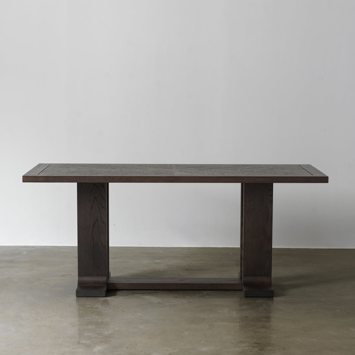 Front view of vintage distressed wood dining table with architectural trestle base and rectangular top