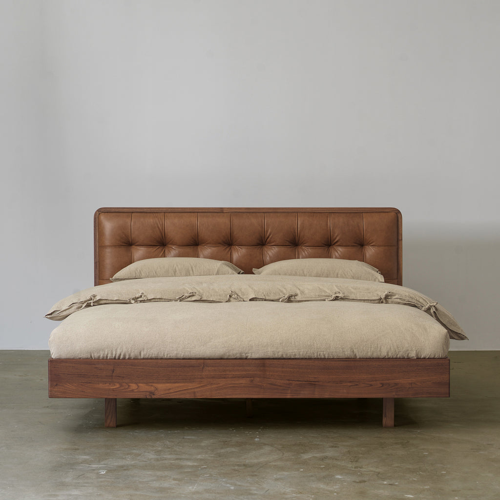 Black walnut bed with tufted cowhide leather headboard front view