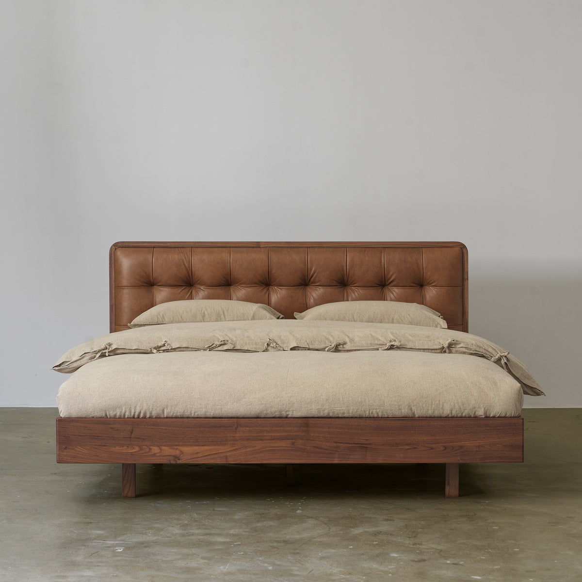 Black walnut bed with tufted cowhide leather headboard front view