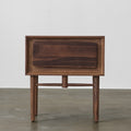 Front view of black walnut single-drawer nightstand with beveled frame and slender tapered legs