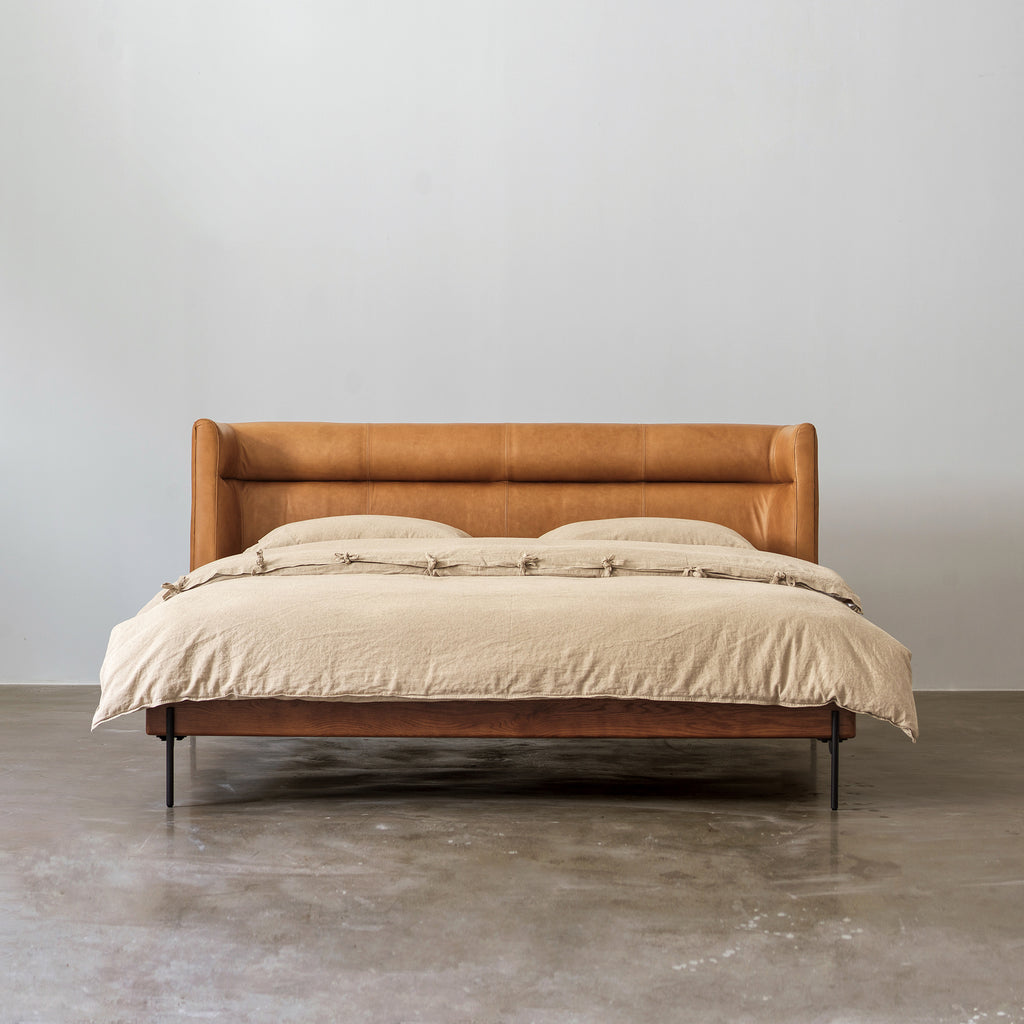 Solid red oak bed with oil-waxed leather headboard front view