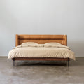 Solid red oak bed with oil-waxed leather headboard front view