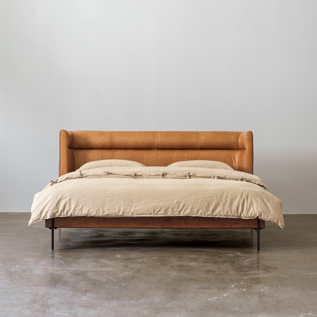 Solid red oak bed with oil-waxed leather headboard front view